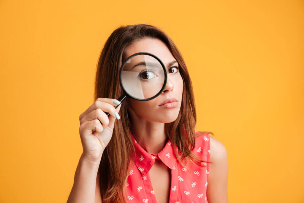 Woman looking through magnifying glass